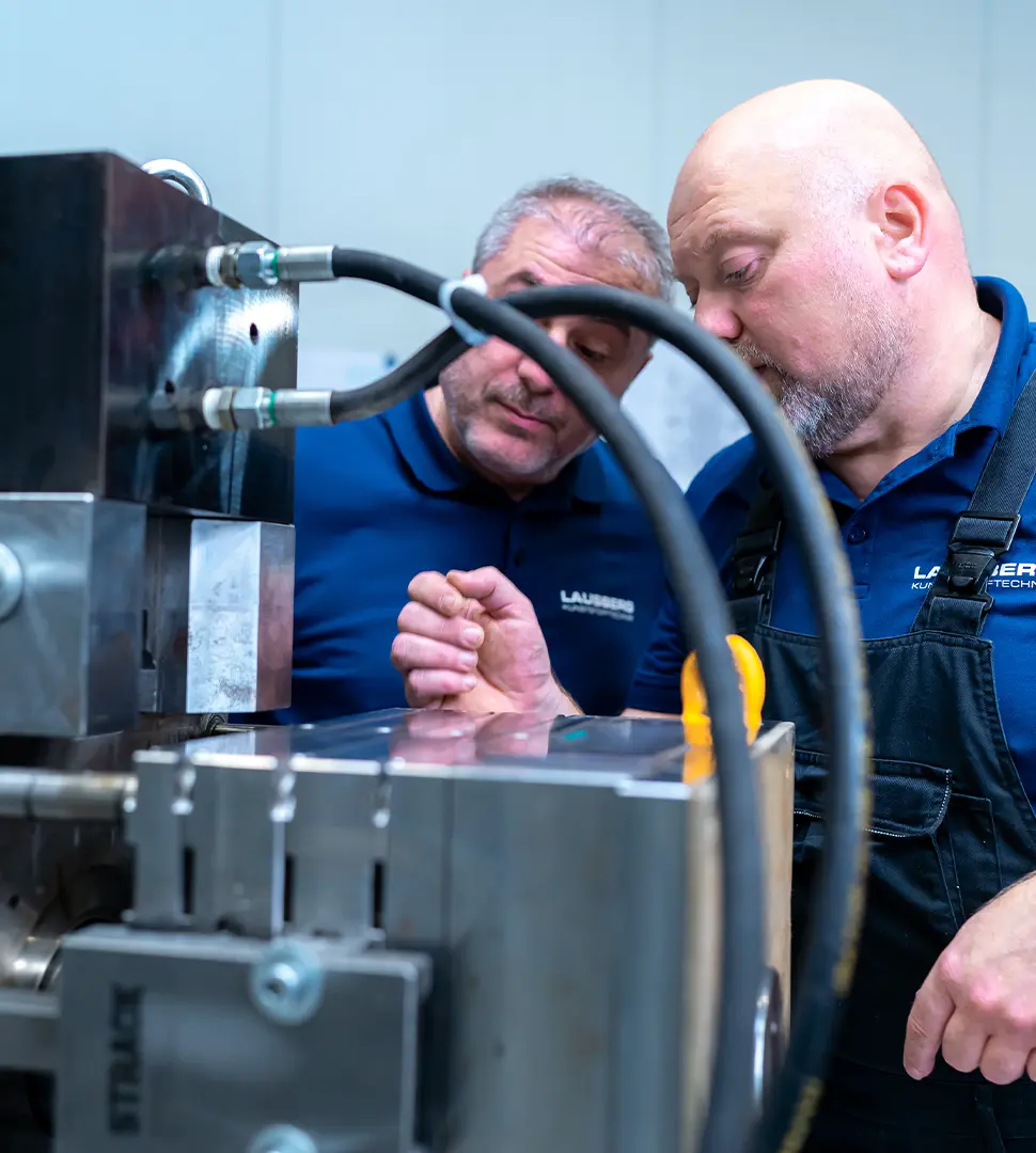 Zwei Mitarbeiter begutachten eine Stahlform